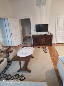 a living room with a tv and a couch and a table at Issy Apartment in Sarajevo