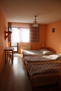 ザコパネにあるPokoje Gościnne Łukaszczykのベッドルーム1室(ベッド2台、テーブル、窓付)
