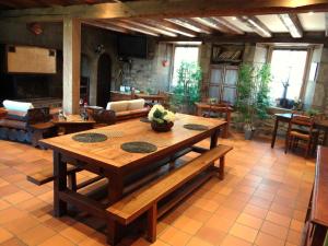 ein großes Wohnzimmer mit einem Holztisch und Stühlen in der Unterkunft La maison de gilbert in Chaudes-Aigues