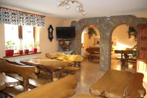 a living room with tables and chairs and a tv at Pokoje Gościnne Łukaszczyk in Zakopane
