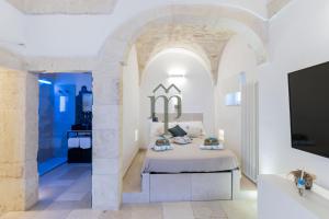 a bedroom with a bed and a tv in a room at Dimora Matteotti by Meravigliosa Puglia RealEstate in Ostuni