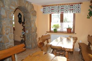 a living room with a table and a stone fireplace at Pokoje Gościnne Łukaszczyk in Zakopane
