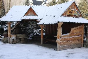 una cabaña de madera con nieve encima en Pokoje Gościnne Łukaszczyk, en Zakopane