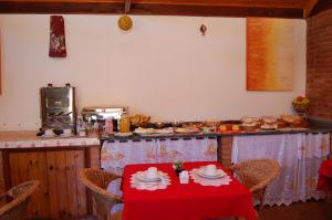 uma cozinha com uma mesa com uma toalha de mesa vermelha em Pousada Aconchego em Monte Verde