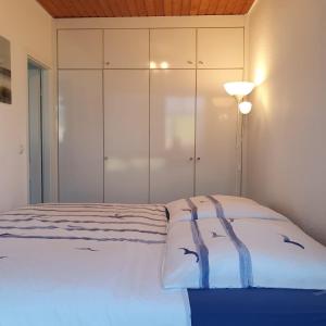 ein Schlafzimmer mit einem Bett und einem weißen Schrank in der Unterkunft Kimbas Huus in Berumbur
