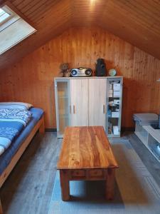 Zimmer mit einem Bett und einem Holztisch in einer Hütte in der Unterkunft Kimbas Huus in Berumbur