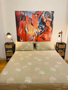 a bedroom with a bed with a painting on the wall at Accogliente Appartamento Spazioso in Grosseto