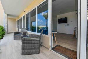 sala de estar con sillas, TV y balcón en Commandeurs Apartments unit 4D, en Oranjestad