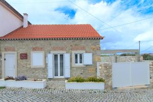 ceglany dom z białymi oknami i czerwonym dachem w obiekcie Solar das Estrelas w Fatimie