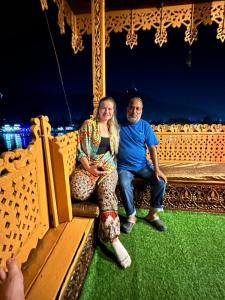 Un uomo e una donna seduti su una giostra di Gulbahaar Group Of HouseBoats a Srinagar