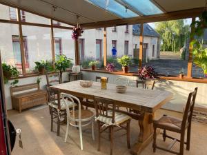 a patio with a wooden table and chairs at Hôtel Les Voisins Beaucemaine in Ploufragan