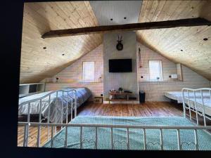 a large room with two beds and a flat screen tv at Agréable maison de village au cœur de Sarrancolin in Sarrancolin