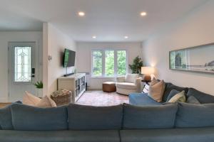 uma sala de estar com um sofá azul e uma televisão em Chalet SPA SAUNA Tremblant em Saint-Faustin