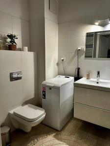 a white bathroom with a toilet and a sink at Apartament Centrum, miejsce parkingowe w cenie in Warsaw