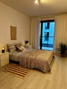 a bedroom with a large bed and a large window at Apartament Centrum, miejsce parkingowe w cenie in Warsaw