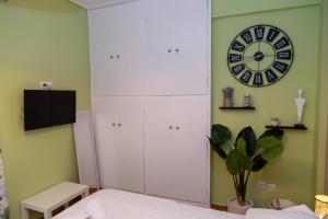 a bedroom with a clock on the wall and a bed at Charming Green Studio across the National Museum in Athens