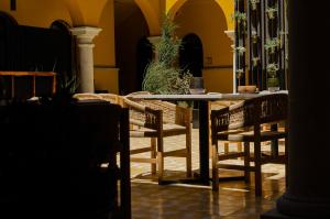 a table and chairs in a room with yellow walls at Hotel Casona Oaxaca in Oaxaca City