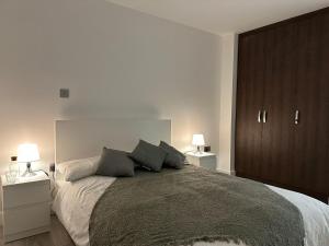 a bedroom with a large bed with two lamps at Kensington House by Solitaire Suites in Slough