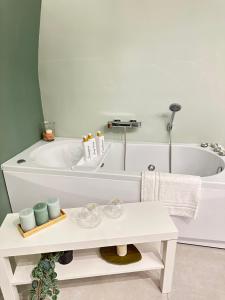 ein Badezimmer mit einer weißen Badewanne und einem weißen Tisch in der Unterkunft CARMA SUITE in Neapel + 25 Fotos