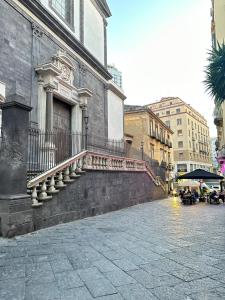 un bâtiment avec un escalier sur le côté d'une rue dans l'établissement CARMA SUITE, à Naples