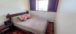 a small bed in a room with a window at Apartamento Ubatuba Vista para o Mar in Ubatuba