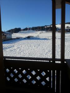 a view of a snow covered field from a window at Pension Panorama in Monguelfo