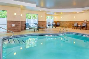 einen Pool in einem Hotelzimmer mit Stühlen und Tischen in der Unterkunft Fairfield Inn & Suites by Marriott Brunswick Freeport in Brunswick