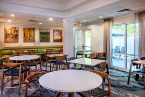 ein Restaurant mit Tischen und Stühlen und einer Couch in der Unterkunft Fairfield Inn & Suites by Marriott Brunswick Freeport in Brunswick