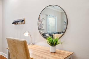 un miroir installé au-dessus d'une table en bois avec une chaise dans l'établissement * Lux Modern Retreat * Downtown * King Beds *, à Durham 24 autres photos