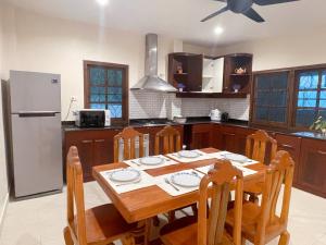 a kitchen with a wooden table and a refrigerator at Patong Beach - Private Pool Villa in Patong Beach