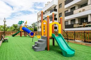 um parque infantil em frente a um edifício com escorrega em Apartamentos a 240m do mar Floripa-SC ADC em Florianópolis