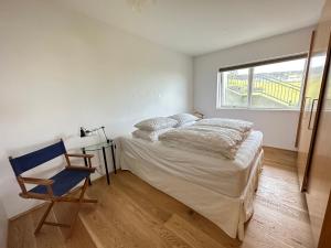 um quarto com uma cama, uma cadeira e uma janela em Apartment in Austurkór- Birta Rentals em Reykjavík