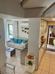 eine Küche und ein Wohnzimmer mit einem Sofa in der Unterkunft BANGALÔ PRAIA DE MURO ALTO/PORTO DE GALINHAS in Porto De Galinhas + 39 Fotos