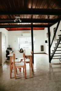Casa Tipo Loft- Tigre Centro في تيغري: غرفة طعام مع طاولة وكراسي ودرج