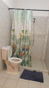 a bathroom with a toilet and a shower curtain at SALY KEUR EMMA in Malikounda Sas