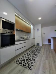 a kitchen with a black and white rug on the floor at Happy Uptown 13 in Funchal