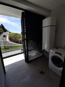 a bathroom with a washing machine and a window at Happy Uptown 13 in Funchal