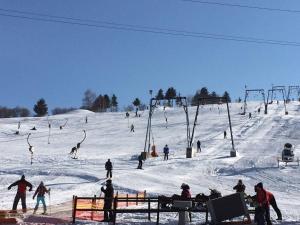 a group of people skiing down a snow covered slope at Skigyimes Guesthouse in Lunca de Sus