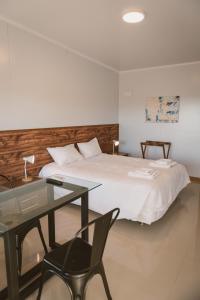 Schlafzimmer mit einem Bett, einem Tisch und einem Schreibtisch in der Unterkunft HOTEL CONCHILLAS in Conchillas