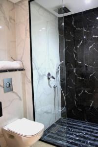 La salle de bains est pourvue d'une douche en verre et de toilettes. dans l'établissement Sublime studio en plein centre, à Casablanca