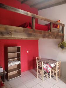 a dining room with a table and a bunk bed at Moradas Renascer 2 in Praia do Rosa