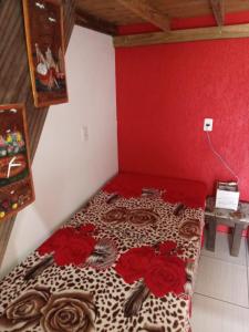 Una habitación con una cama con rosas. en Moradas Renascer 2, en Praia do Rosa