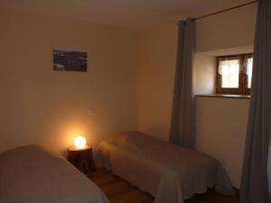 um quarto com duas camas e um candeeiro sobre uma mesa em Gite Le Millepertuis - Proche Site Alésia em Darcey