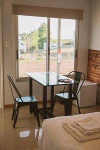 einen Tisch und zwei Stühle in einem Zimmer mit Fenster in der Unterkunft HOTEL CONCHILLAS in Conchillas