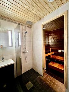 y baño con ducha y lavamanos. en Lapland Tunturimaja Ski in, sauna, in Pyhä center - Lapland Villas en Pyhätunturi