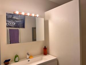 a bathroom with a sink and a mirror at Chambre cozy spacieuse, intra-muros, clim, parking in Aigues-Mortes
