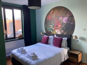 um quarto com uma cama com uma grande pintura na parede em Rue Haute by M&M 4 sterren bed en breakfast vlakbij Maastricht em Eben-Emael