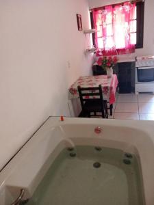 a bath tub in a kitchen with a table at Moradas Renascer 2 in Praia do Rosa