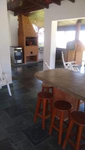a kitchen with a wooden table and stools at Casa para finais de semana temporada in Caraguatatuba