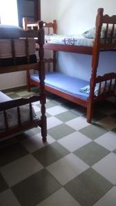 two bunk beds in a room with a checkered floor at Casa para finais de semana temporada in Caraguatatuba